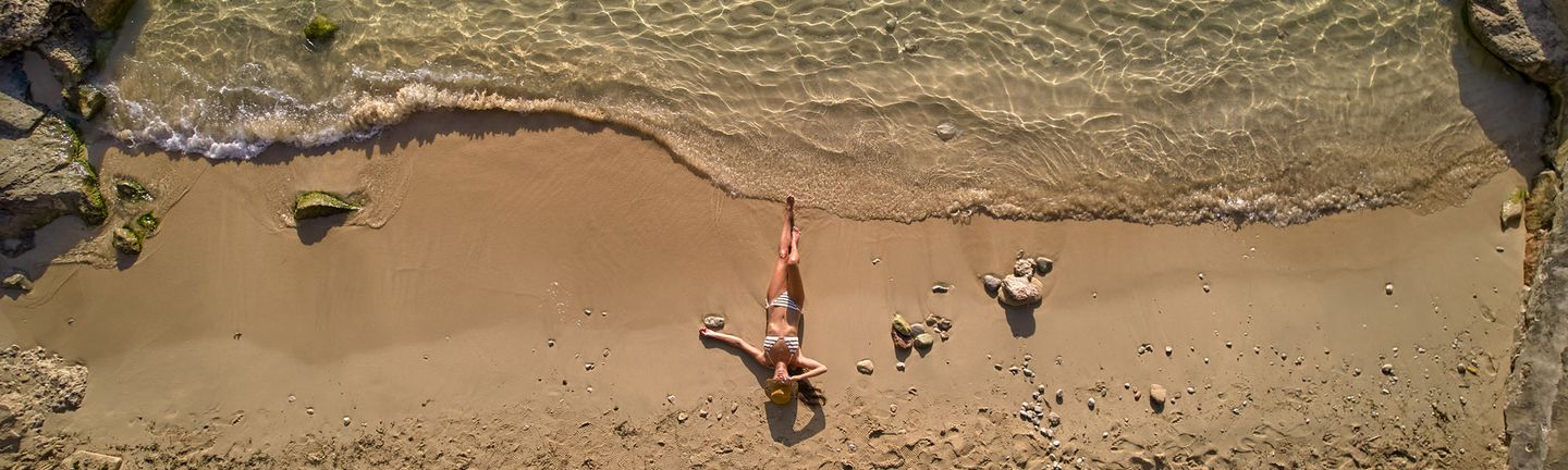 Universal Mallorca Travel Reisegarantie Garantiert hin und zurück Frau am Strand