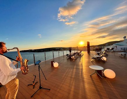 Blick von der Sky Bar auf die Bucht von Magaluf bei Abenddämmerung inkl. Saxophonspieler